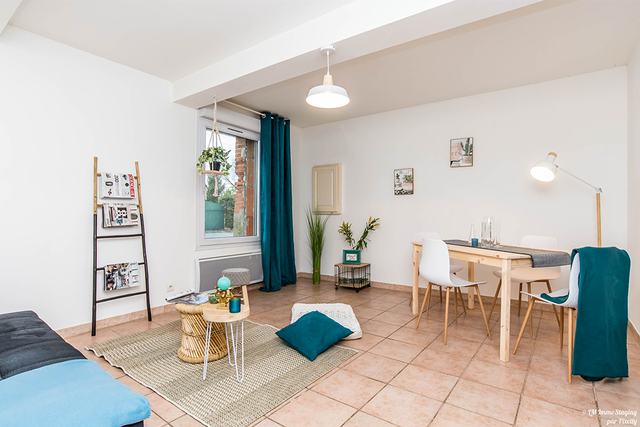 La même pièce mise en scène, table dressée et rideaux posés